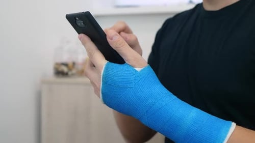 Person With Blue Cast Using Smartphone