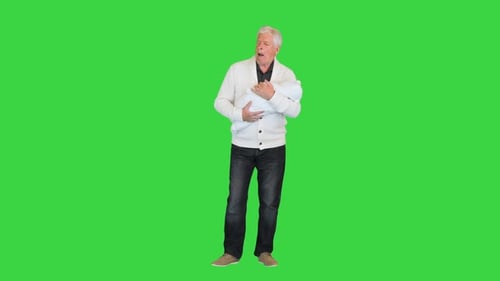 Sleepy and Tired Grandfather Holding Toddler on a Green Screen Chroma Key