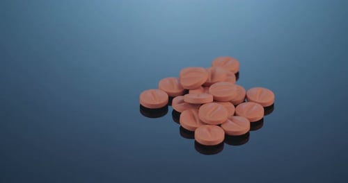 Close Up of Orange Pills on Blue Surface