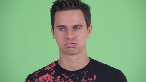 Man Rolls Eyes in Annoyance on Green Background