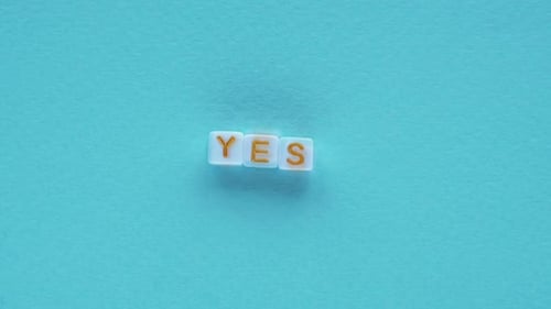 Block Letters Spell 'Yes' on Blue Background