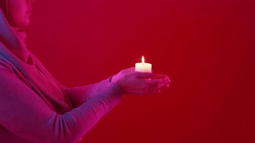 Woman Holds Burning Candle with Gentle Hands