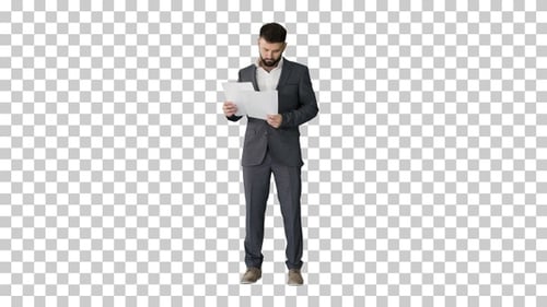 Businessman standing and reading papers seriously, Alpha Channel
