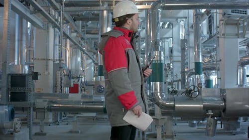 Ingenieur arbeitet in einem Wärmekraftwerk mit Talking on the Walkie-Talkie zur Steuerung der Arbeit
