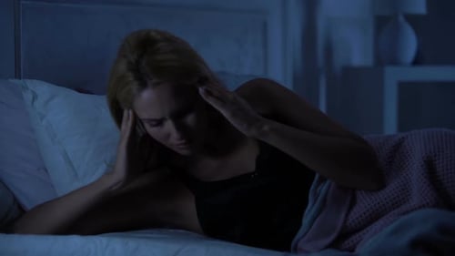Woman with Headache Lying Awake at Night