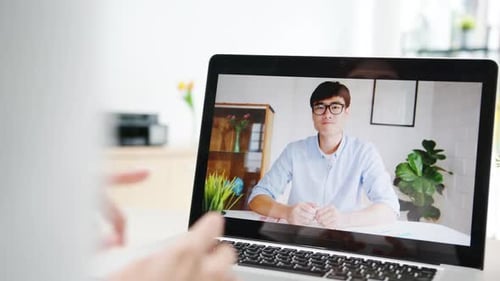 Adults Participate in Video Call on Laptop