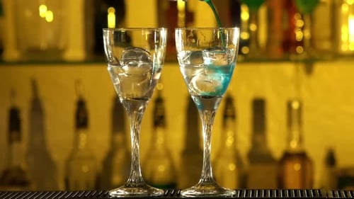Adding Blue Drink to Glass with Ice in Bar