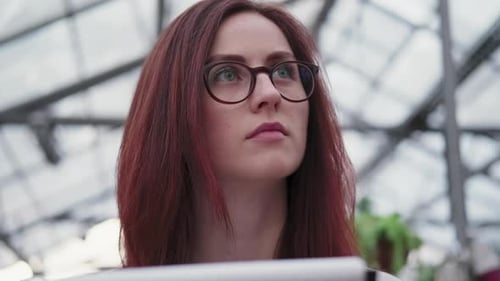 Woman Studies Plants Inside Greenhouse