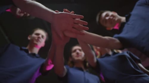 Team of Young Adults Putting Hands Together