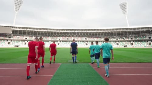 Los jugadores de fútbol profesional caminan hacia el estadio Los equipos de fútbol rivales caminan por el estadio: Vista posterior