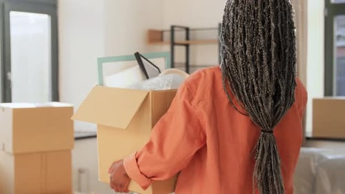Young Adult Moving into New Apartment with Boxes