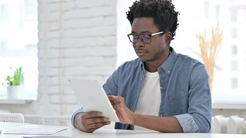 Young African Man Using Tablet in Office
