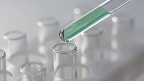 Green Liquid Being Added to Test Tube