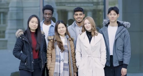 Multiracial group of college student friends portrait smiling and looking at
