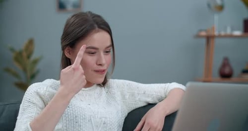 Millennial-Frau, die Video, während sie den Laptop benutzt. Schöne Frau lächelt und