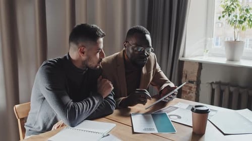 Young Businessmen Discussing Financial Documents