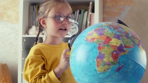 Girl Studying Globe with Magnifying Glass