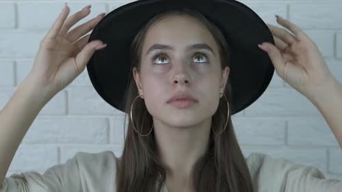 Portrait of a beautiful girl in a black hat.