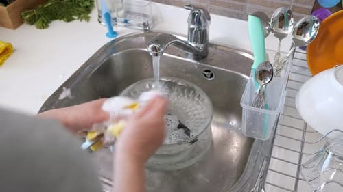 Woman Is Washing Cutlery By Hands in the Kitchen at Home.