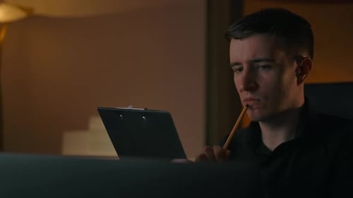 A Man Teaches a Lesson Thinks and Makes a Note in a Text Tablet