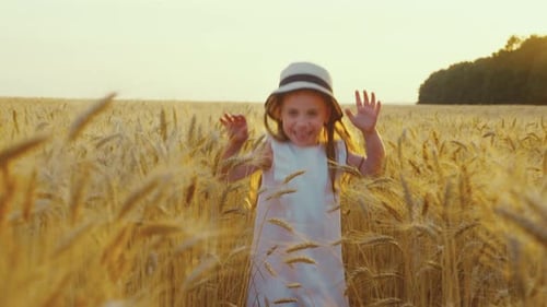 Happy Little Girl Running in Wheat Field