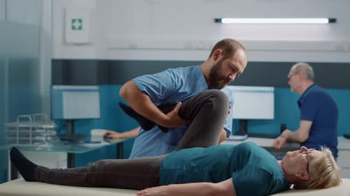 Senior Woman Receiving Leg Manipulation from Medical Worker