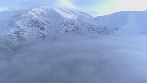 Fog covering Frozen mountain peaks during winter