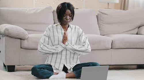 Woman Meditating Calmly in Front of Laptop