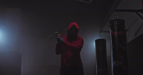 Male Athlete Jumping Rope in a Dark Gym Training