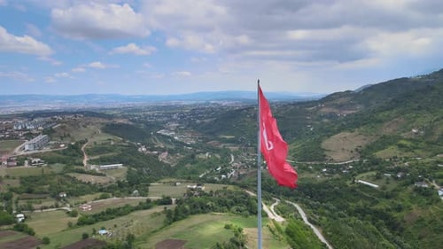 Flag Waving Over Rolling Green Hills, Aerial View