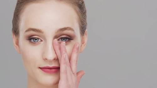 Studio portrait of young, beautiful and natural woman over grey background.