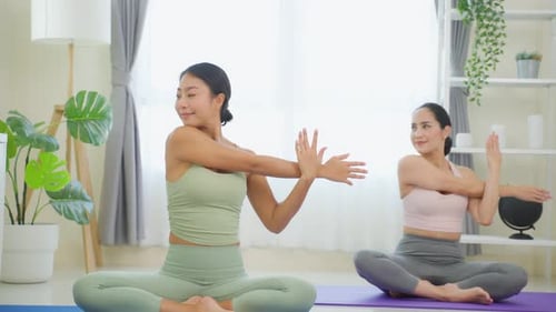 Asiatische aktive Sportlerin lernt mit einem Coach-Trainer eine Yoga-Pilates-Lektion.
