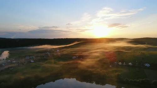 Evening Fog Descends on the Lake and a Small Village at Sunset