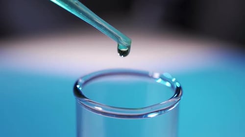 Pipette Drops Liquid into Glass Test Tube Close-Up
