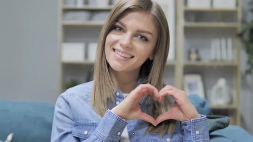 Woman Makes Heart Shape With Hands Smiling