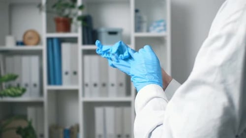 L'infirmière met des gants médicaux bleus, le médecin met des gants de protection en latex pour l'examen