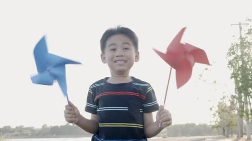 Asian child boy playing with pinwheels