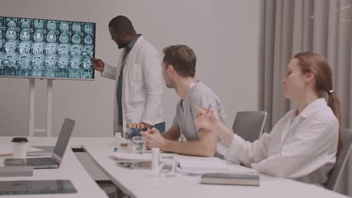 Medical Professionals Review Brain Scan in Modern Office