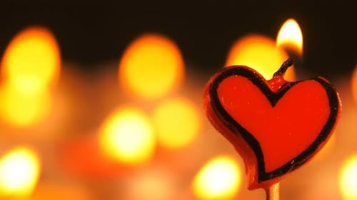 Glowing Heart Candle with Warm Bokeh Background
