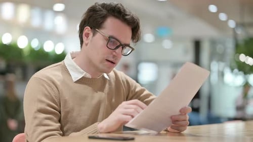 Man Excitedly Reading Document Inside