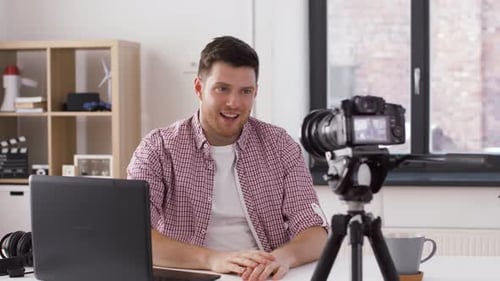 Young Adult Man Recording Video Blog at Desk