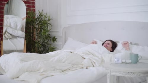 Young Adult Waking Up in Bright Bedroom