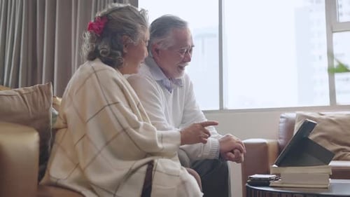 Elderly Couple Video Chatting with Tablet at Home