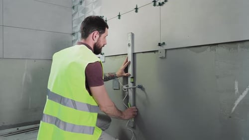 Man Installing Tiles in a Bathroom