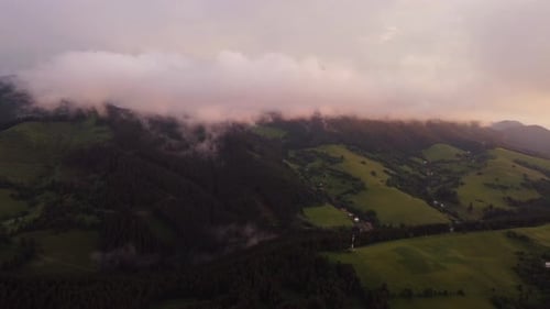 Aerial view , Hilly rural landscape after a storm shrouded in clouds at dusk in the golden hour.