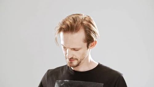 Young Handsome Man Smiling Winking Over Grey Background