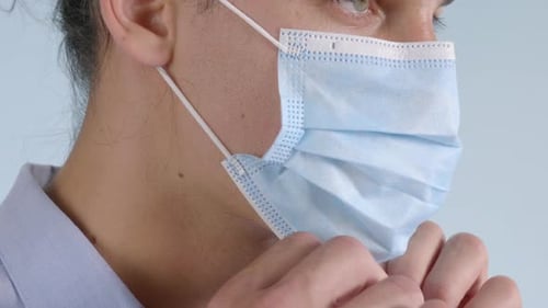 Close-up portrait of a man wearing a safety surgical face mask. Safe way to avoid getting infected.