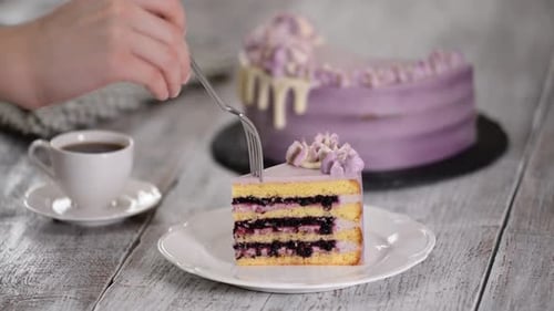 Fork Cuts Blueberry Cake Next to Coffee Cup