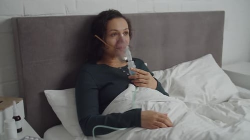 Femme mettant un masque, un nébuliseur, inhalant des vapeurs de médicaments dans les poumons