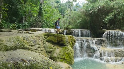 Young Adult Exploring Tropical Waterfall Landscape